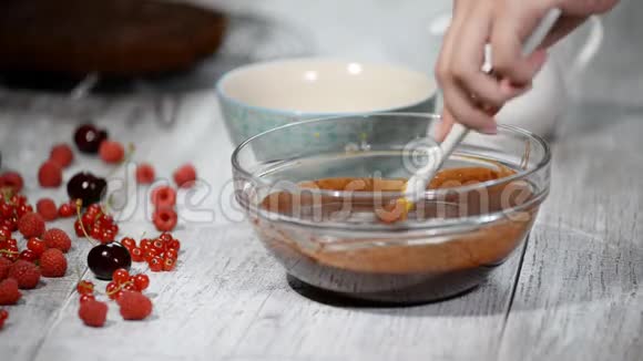 家庭主妇做自制巧克力女人用搅拌器混合配料在家做巧克力蛋糕面包店视频的预览图