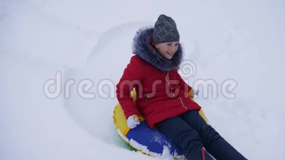 少女在圣诞节假期在一个冬季公园玩耍冬天女孩在雪中滑过从高高的山坡上滑过雪橇和一个视频的预览图