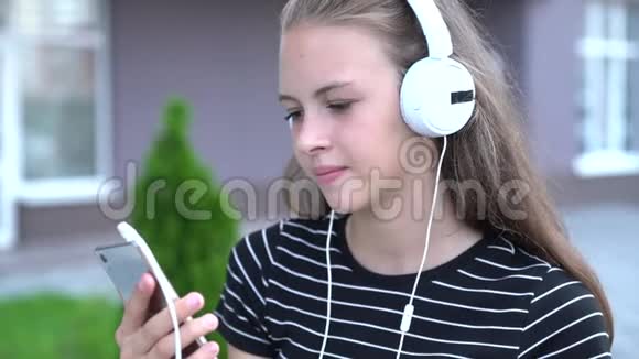 年轻女子一边笑着看着手机视频的预览图