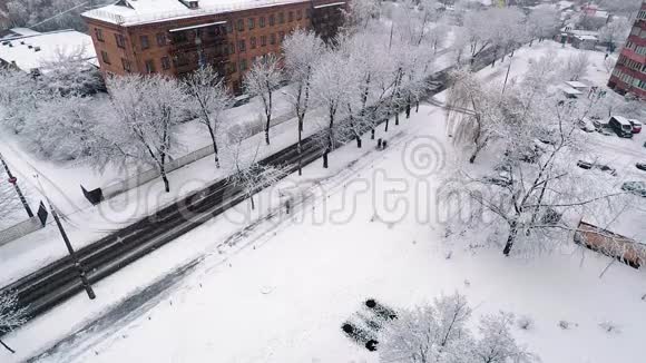 大雪纷飞的城市里大片大片大片大片的雪花在缓缓盘旋从一栋高楼上拍下来行人在沿着视频的预览图