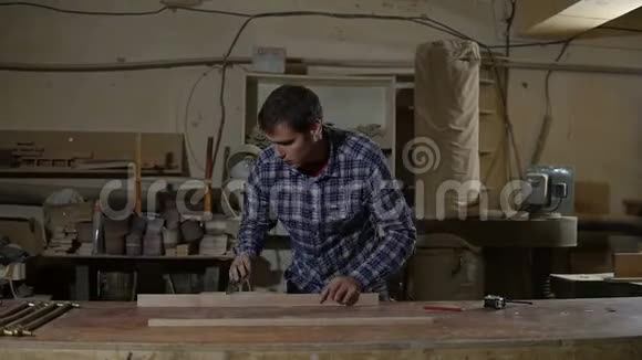 木工在桌面上用砂纸打磨木板木工车间的工作视频的预览图