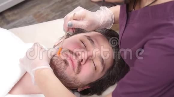 美容和面部的概念女人美容师为男人做脸部和胡须的造型视频的预览图