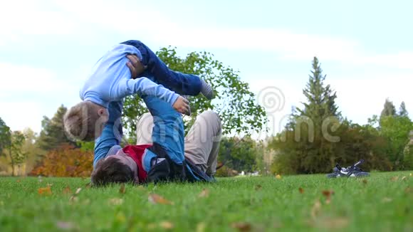 幸福的一家人在草坪上玩耍一位年轻慈爱的父亲把孩子高高地举过头顶孩子微笑着反对视频的预览图