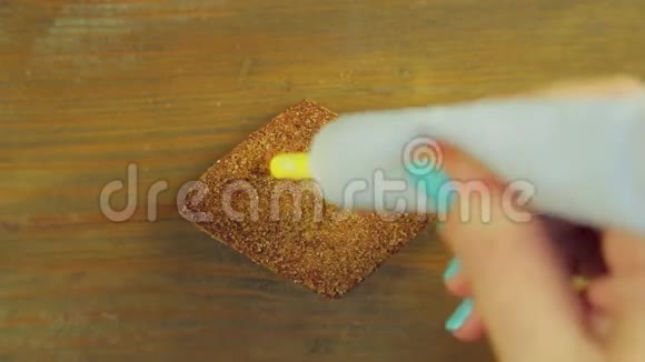 一只手拿着一管煮饭的颜料用黄色颜料在巧克力饼干上画了五个视频的预览图