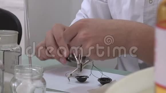药剂师用小的旧天平测量药房中药物的重量视频的预览图