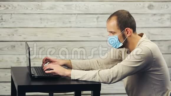 一个戴着医用口罩的男人在电脑里工作咳嗽视频的预览图