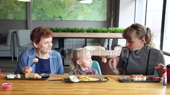 祖母和母亲轮流喂小女孩视频的预览图