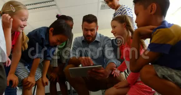 成人白种人男教师在4k教室用数码平板电脑教学童视频的预览图