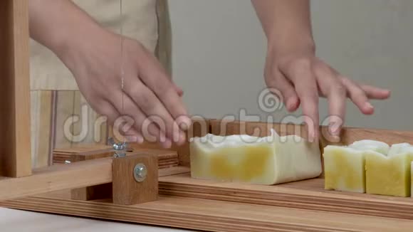 一个女人的特写她的手把肥皂切成了肥皂切割机上的棒视频的预览图