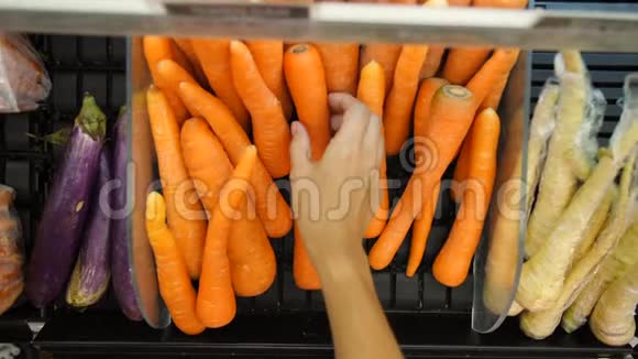 年轻的素食主义者在杂货店里选择胡萝卜有机水果和蔬菜购物4K印度尼西亚巴厘视频的预览图