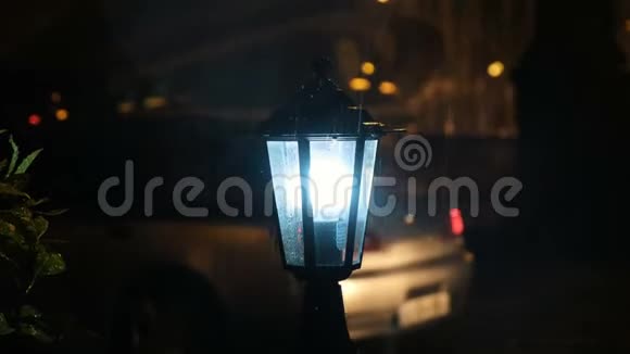 雨点打在路灯上灯光照在汽车的背景下视频的预览图