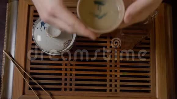 亲密的茶友从木桌上端起绿茶杯视频的预览图