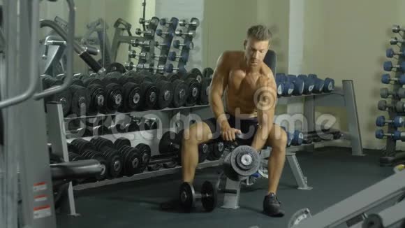 一位年轻英俊的运动员正积极地在健身房锻炼双手训练一只手视频的预览图
