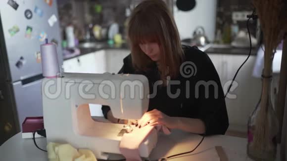 女时装设计师裁缝裁缝裁缝晚上在家做缝纫机红发女工视频的预览图