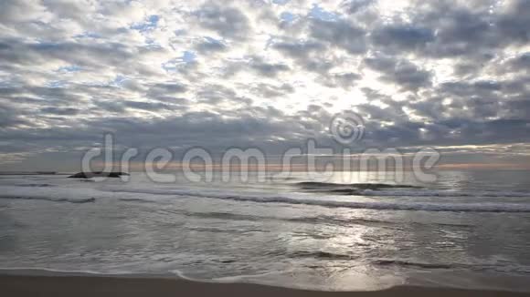 波浪以多云的天空到达海滩视频的预览图