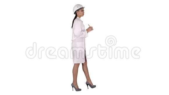 戴着头盔的女工程师拿着笔和清单在白色背景下行走时放下一些东西视频的预览图