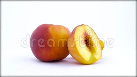 一整两份熟桃果实在白色背景上隔离的转盘上旋转快关门视频的预览图