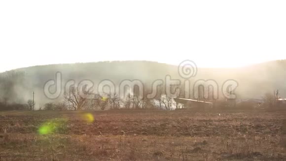 水平全景燃烧的草地附近的森林和大量的烟雾旁边的木屋日落山视频的预览图