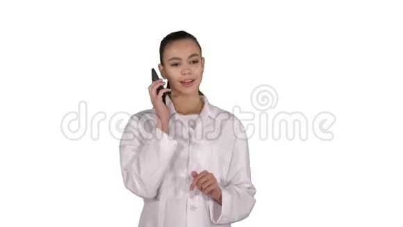 微笑的女医生在电话里说话而走在白色的背景上视频的预览图