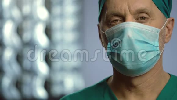 有经验的脊柱外科医生严肃的男人戴着面罩看着摄像机视频的预览图