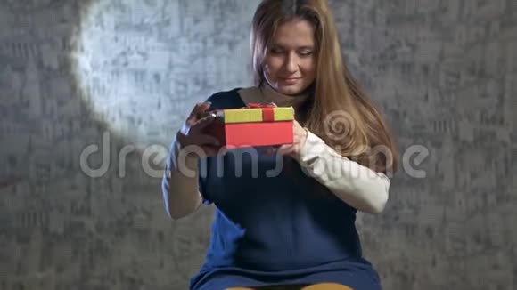 美丽的女孩打开一个红色的礼物视频的预览图