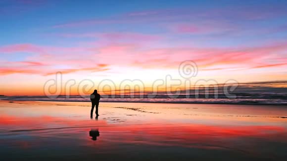 日落时分海滩上孤独的男人视频的预览图