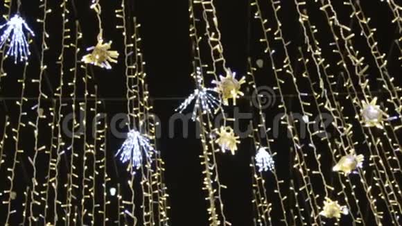 为圣诞节和新年庆祝而装饰的街道装饰灯光花环的底部景观视频的预览图