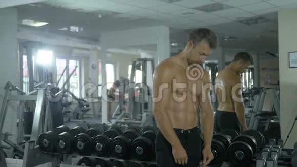 漂亮的教练运动员光着胸照镜子锻炼肌肉视频的预览图