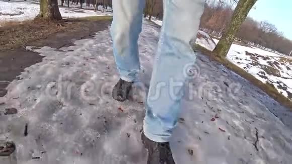 穿着蓝色牛仔裤的人在冬天在雪地里散步双腿合拢角度很宽视频的预览图