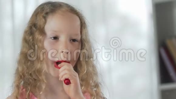 小女孩在镜子前涂了红口红对自己微笑视频的预览图