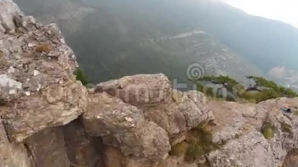 无人机飞在山上的岩石和树附近视频的预览图