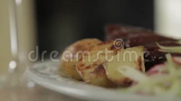烧烤排骨与烤土豆和凉拌菜在盘子上选择性聚焦视频的预览图