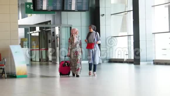 两个美丽的穆斯林女孩在旅行前在车站散步视频的预览图