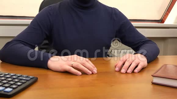 一个男人把一个小球旋在办公桌上视频的预览图