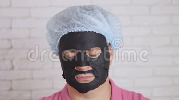 一个人用黑色布面膜敷脸闭着眼睛把头转向两边视频的预览图