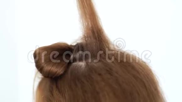 发型师用梳头做蓬松的头发为美容院的年轻女性创造体积发型关门视频的预览图