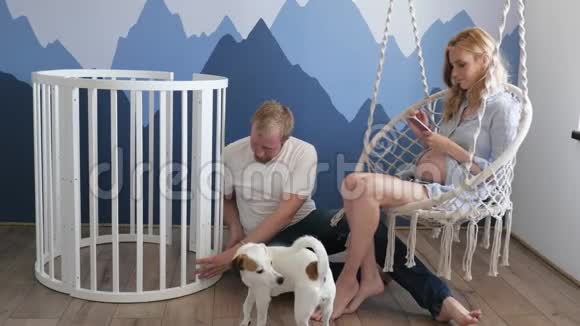 一个年轻的家庭期待着一个孩子和他们的狗杰克罗素玩耍一个女人和一个男人正在玩狗视频的预览图
