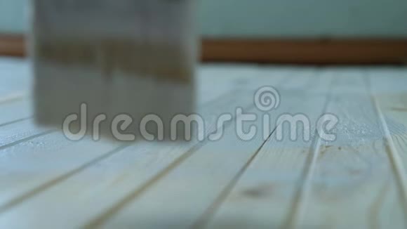 女孩用白色油漆慢慢地画一个木地板特写视频的预览图