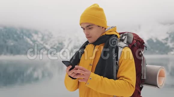 徒步旅行者使用智能手机拍摄冬季自然的照片游客崇尚自然制作照片年轻人视频的预览图