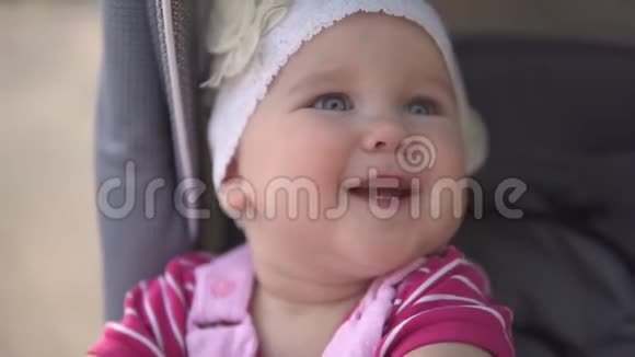 小女孩坐在婴儿车里微笑着慢镜头视频的预览图
