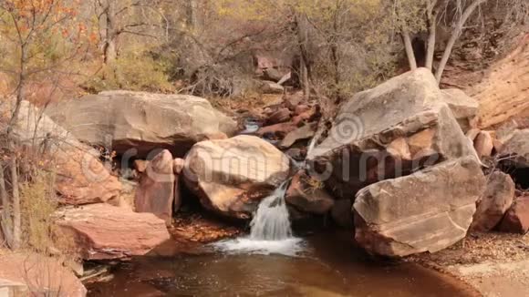 锡安国家公园左叉地铁上的一个小瀑布倾泻在砂岩巨石上视频的预览图