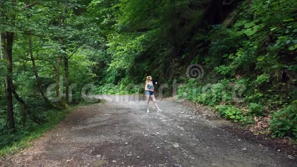 这位女博主留着一张唱片走在山里的树林里自然风景如画4k慢动作视频的预览图