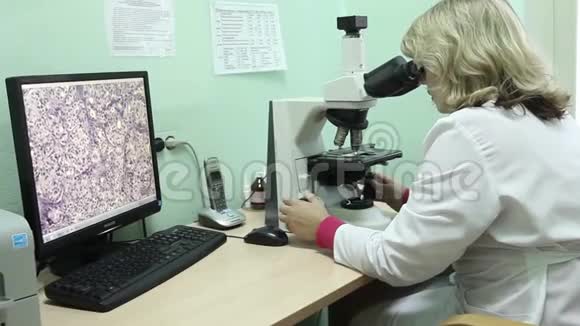 一名女实验室技术人员使用显微镜视频的预览图