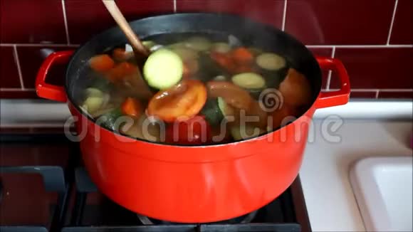 女性手把汤混合在红锅里视频的预览图
