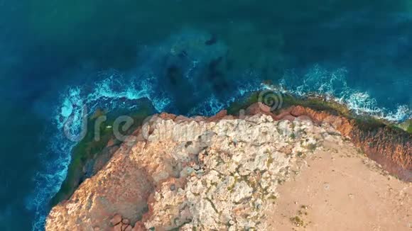 4k鸟瞰图俯视图向前移动越过地中海海岸线悬崖边缘有白色的沙子和绿松石的海洋视频的预览图