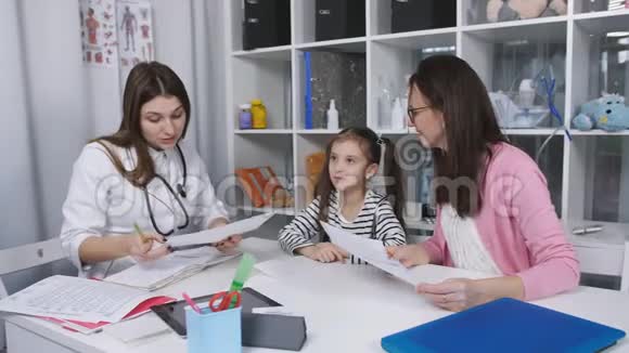 母女俩在诊所看病女医生和母亲和孩子谈话给她一点视频的预览图