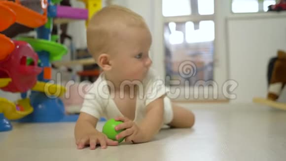 活跃的婴儿玩玩具爬地板特写视频的预览图