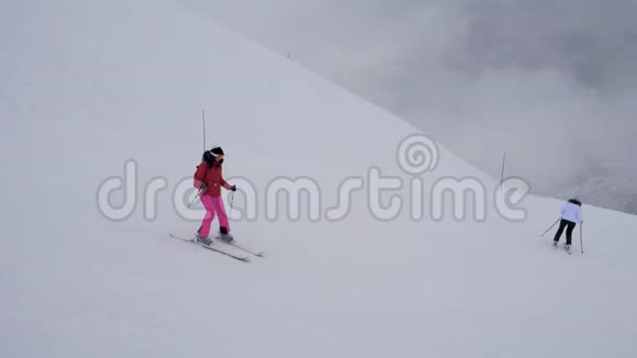 两名运动女滑雪运动员在大雪中的冬季下山滑雪视频的预览图