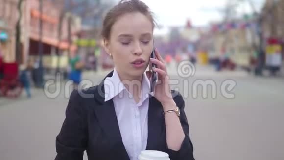 年轻的成功女商人在市中心使用智能手机职业女性雇主与她交谈视频的预览图