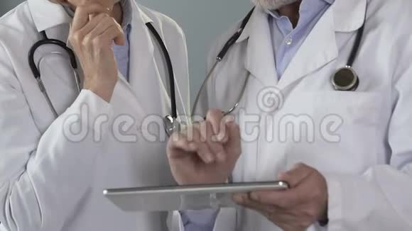 医生在平板电脑上检查电子病历正在进行诊断视频的预览图